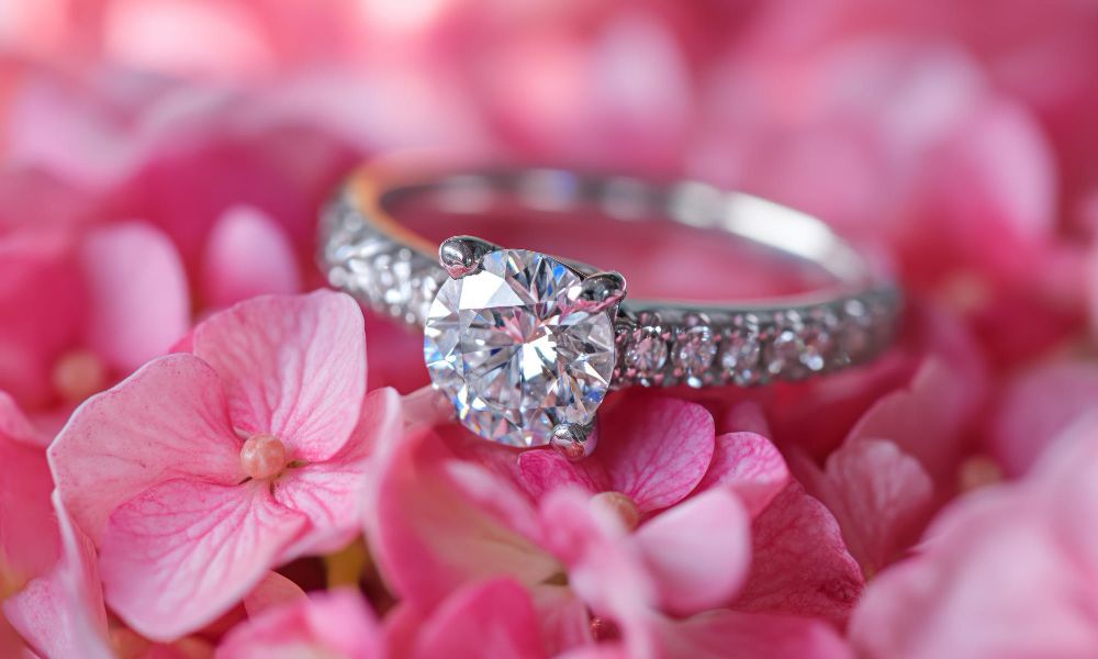 Diamond engagement ring on a pink floral background luxury female jewelry